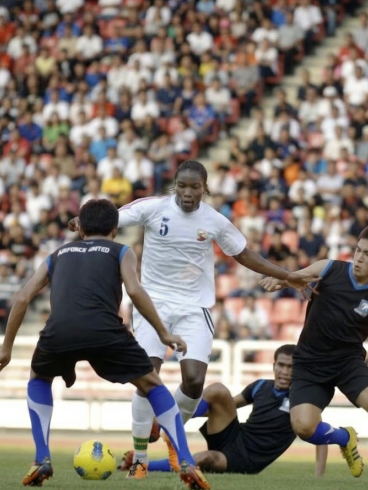 Robert Lamptey playing professional football in front of a packed stadium